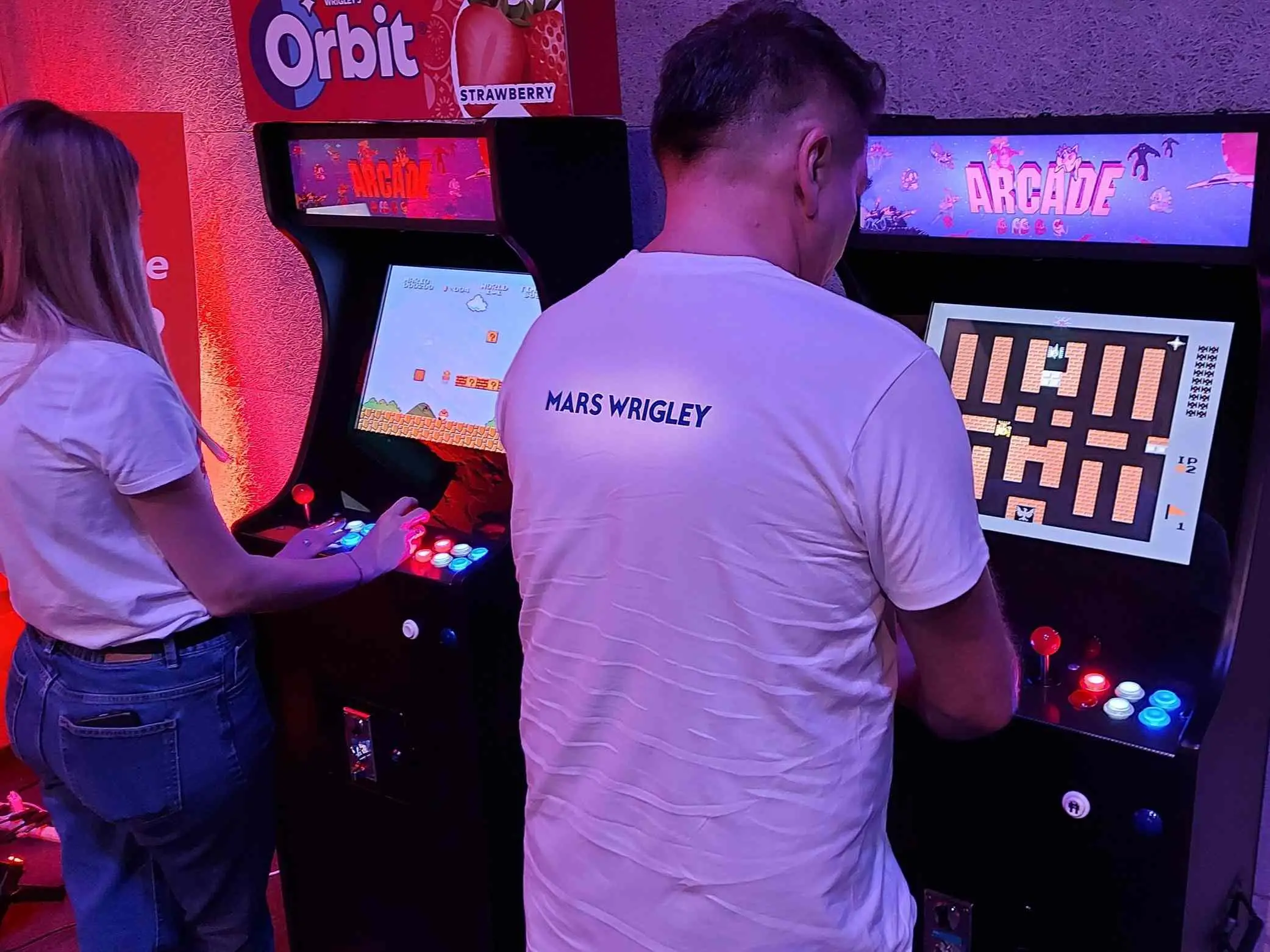 Goście grają w retro gry na automatach arcade podczas imprezy firmowej